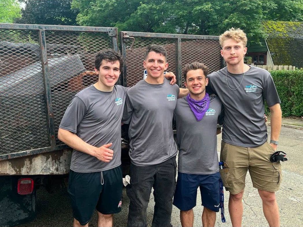 Four Breakaway crew members smiling in front of their trailer