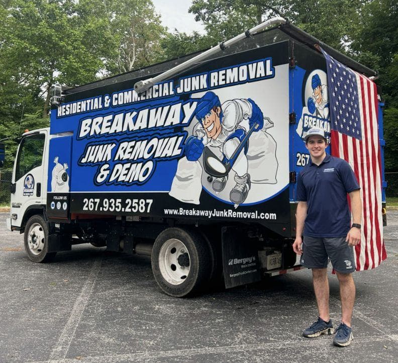 A Breakaway crew member standing beside the branded box truck